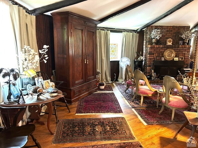 interior space with beam ceiling, a fireplace, and light hardwood / wood-style floors