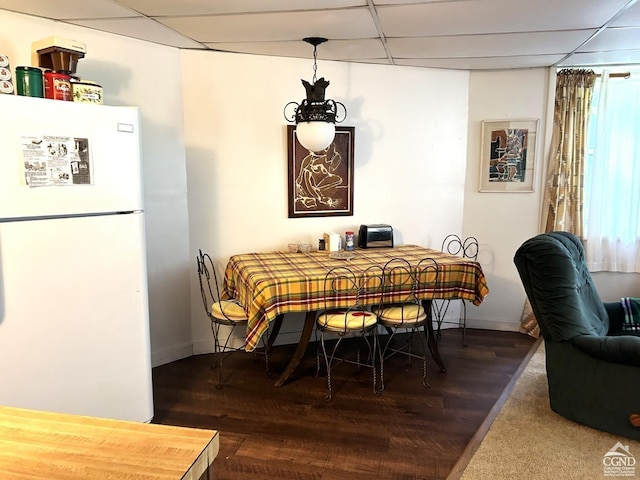 dining area with hardwood / wood-style flooring and a paneled ceiling