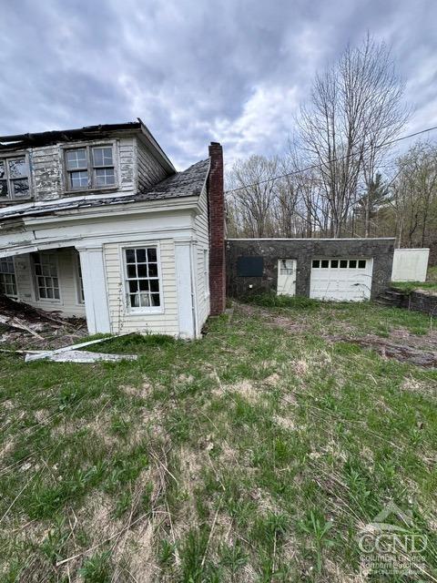 view of side of home featuring an outbuilding and a garage