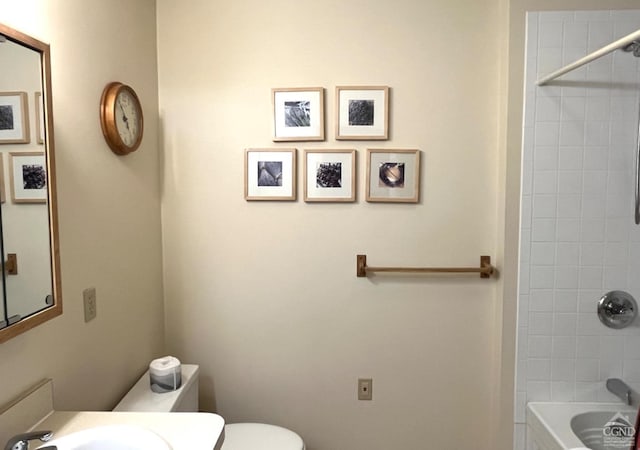 full bathroom with toilet, tiled shower / bath, and sink