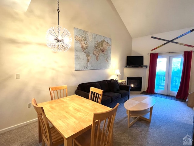 carpeted dining area featuring high vaulted ceiling and a notable chandelier