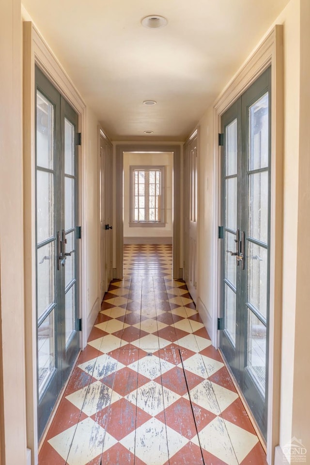 corridor featuring french doors and light tile patterned floors