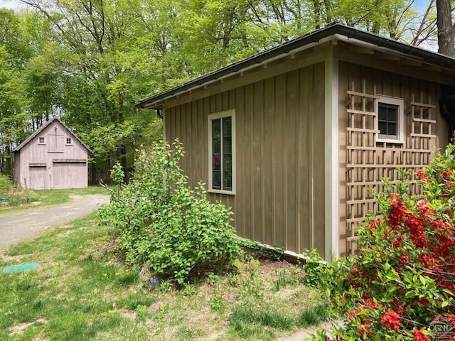 view of outbuilding with dirt driveway and an outbuilding