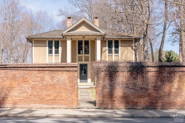 view of front of home with a chimney and board and batten siding