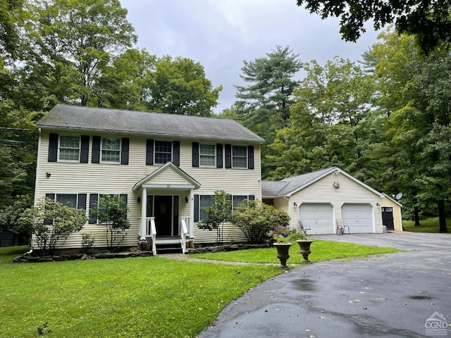 colonial home featuring a garage and a front lawn