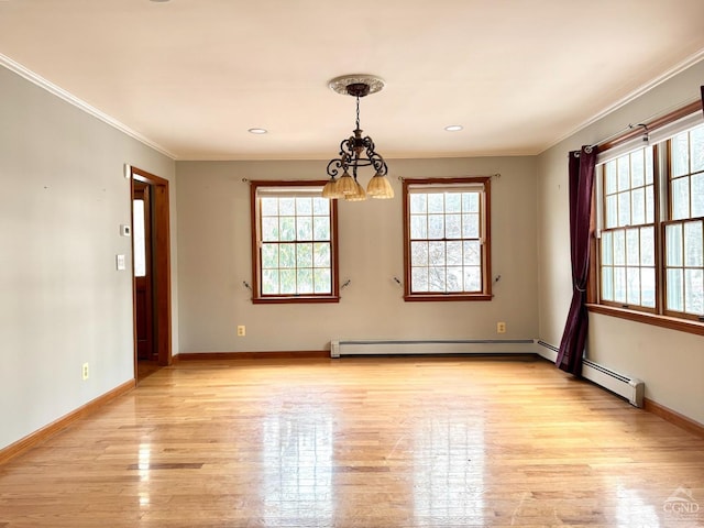 spare room with light wood-type flooring, ornamental molding, plenty of natural light, and a notable chandelier