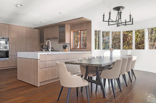 kitchen featuring a notable chandelier, dark hardwood / wood-style floors, sink, and backsplash