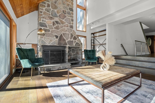 living room with a stone fireplace, wooden ceiling, high vaulted ceiling, and wood-type flooring