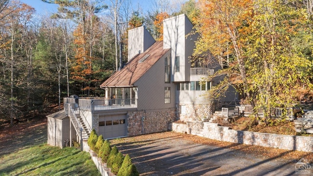 view of property exterior with a garage and a balcony