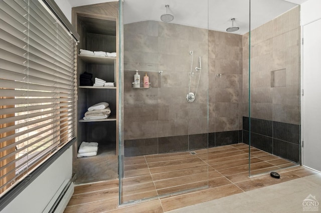 bathroom featuring a tile shower, wood-type flooring, and a baseboard radiator