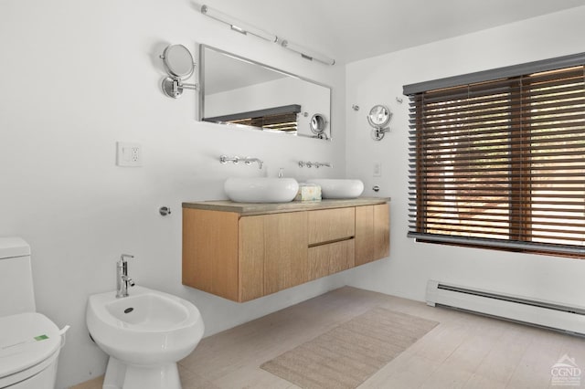 bathroom featuring vanity, a bidet, a baseboard radiator, and toilet