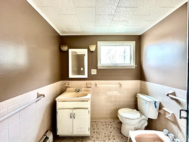 bathroom featuring tile patterned floors, a bidet, toilet, vanity, and tile walls