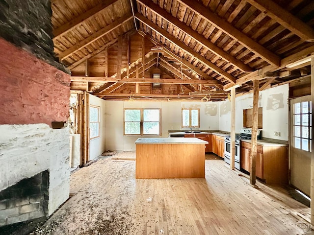 kitchen featuring vaulted ceiling with beams, light hardwood / wood-style flooring, kitchen peninsula, wood ceiling, and stainless steel range with gas stovetop