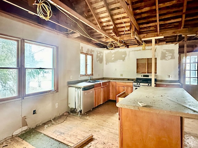 kitchen with appliances with stainless steel finishes, light stone counters, vaulted ceiling, and sink