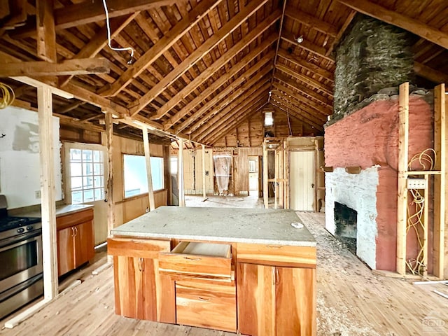 misc room with a fireplace, lofted ceiling with beams, and light hardwood / wood-style floors