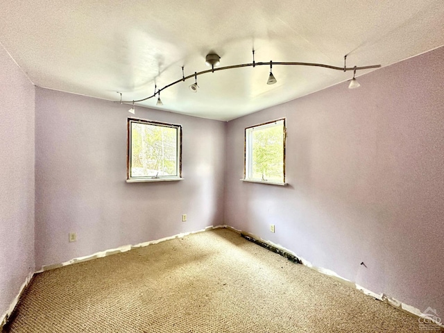 carpeted spare room with plenty of natural light and a textured ceiling