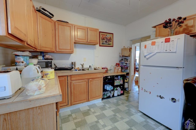 kitchen featuring light brown cabinets, white appliances, ornamental molding, and sink