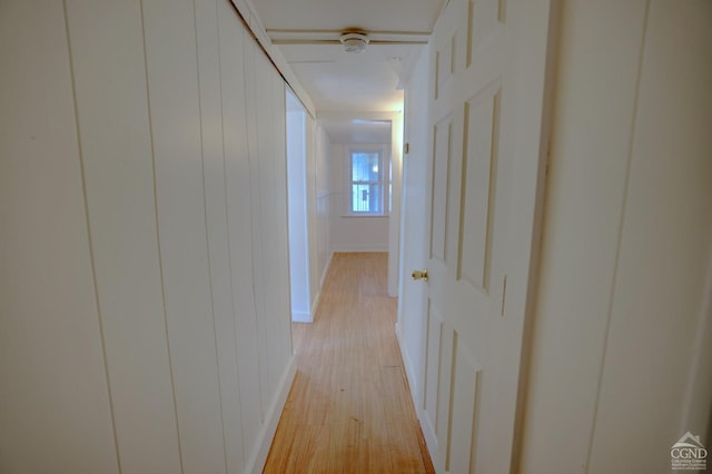 corridor with wood walls and light hardwood / wood-style floors