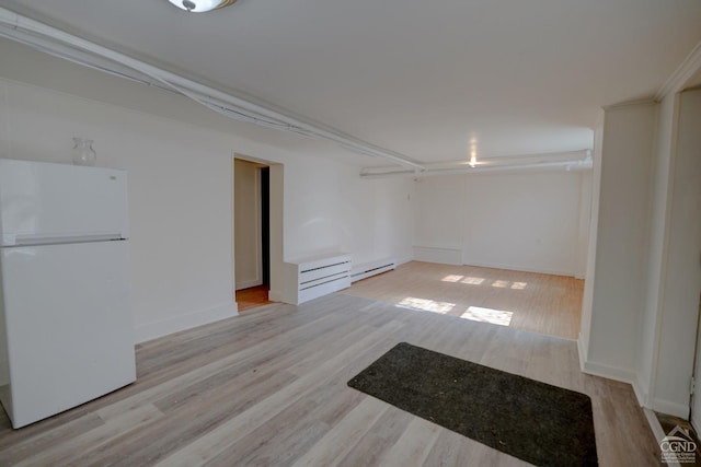 unfurnished room featuring a baseboard radiator, light hardwood / wood-style flooring, and crown molding