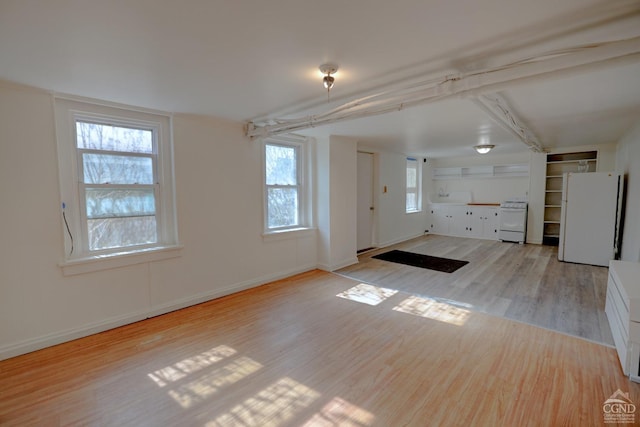 interior space featuring beamed ceiling and light hardwood / wood-style floors