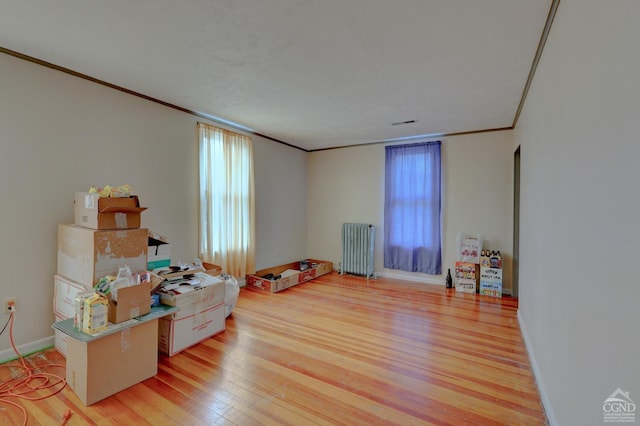 misc room with crown molding, radiator, and light hardwood / wood-style flooring