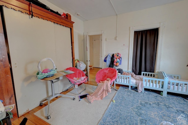 bedroom featuring a nursery area and light hardwood / wood-style flooring