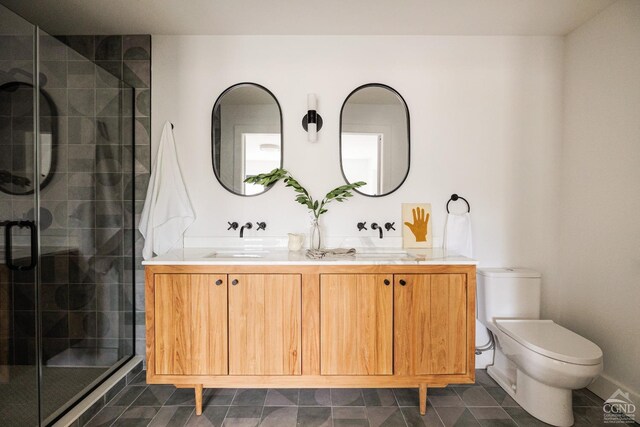 bathroom with double vanity, a sink, a stall shower, and toilet
