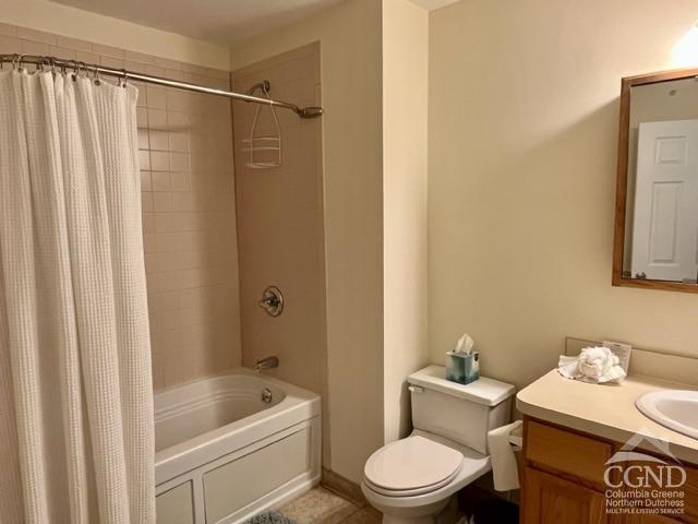 full bathroom with vanity, shower / bath combo, and toilet