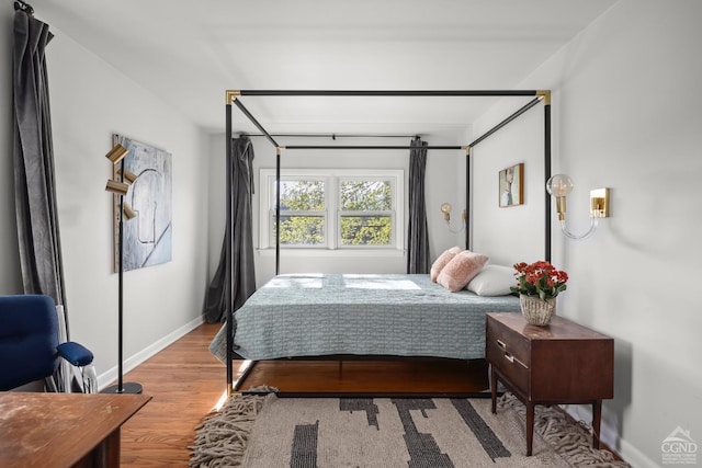 bedroom featuring baseboards and wood finished floors