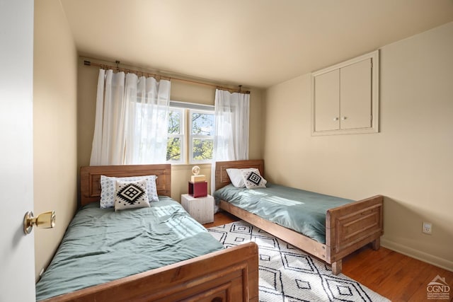 bedroom with light wood-style flooring and baseboards