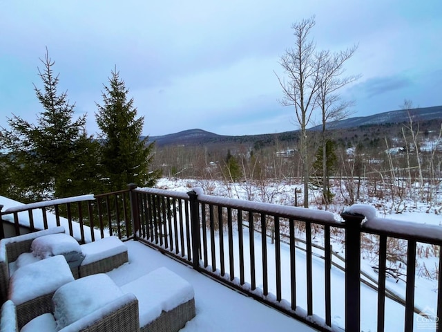 snow covered back of property with a mountain view