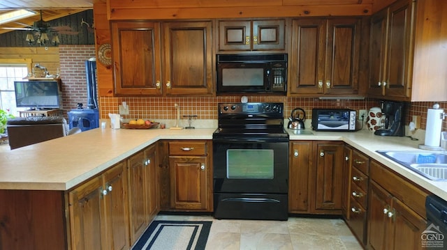 kitchen featuring kitchen peninsula, decorative backsplash, sink, and black appliances