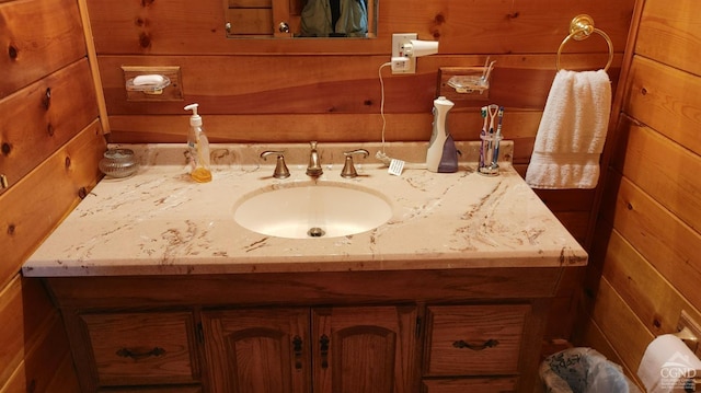 bathroom featuring wood walls and sink