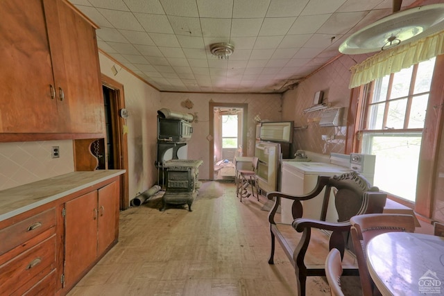 dining area featuring a wood stove, ornamental molding, and washer / clothes dryer