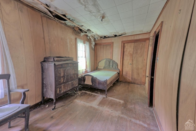 bedroom featuring hardwood / wood-style floors and wood walls