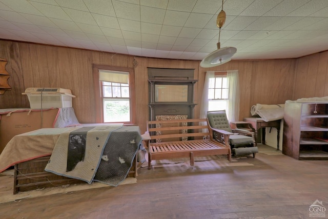 bedroom with wooden walls and hardwood / wood-style floors