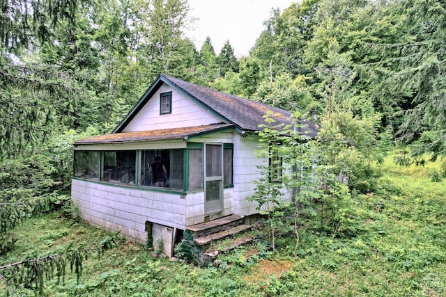 view of property exterior with a sunroom