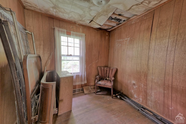 unfurnished room featuring light wood-type flooring and wood walls