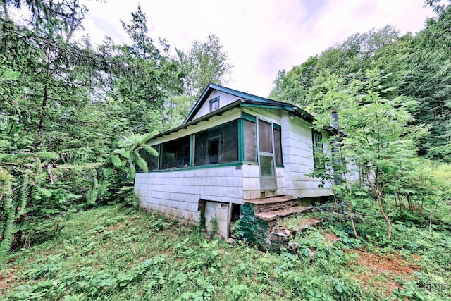 view of home's exterior with a sunroom