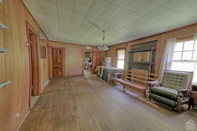 sitting room with hardwood / wood-style floors and wooden walls