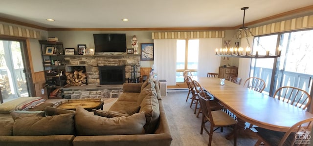 carpeted dining room featuring a stone fireplace, an inviting chandelier, recessed lighting, and ornamental molding