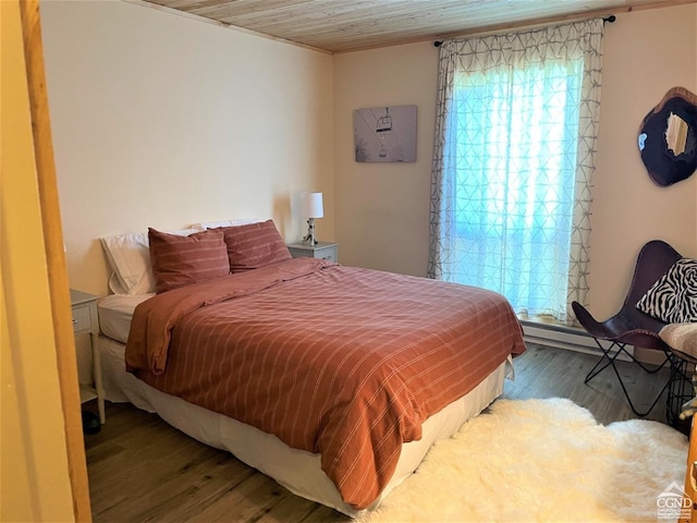 bedroom with wood ceiling, wood-type flooring, and a baseboard heating unit