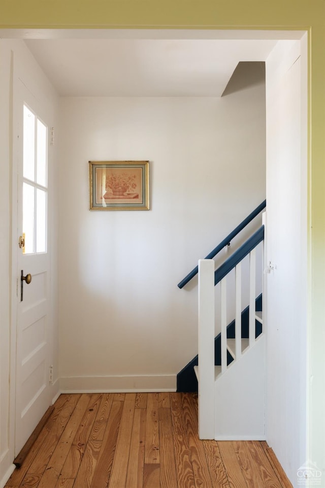 stairway featuring wood finished floors and baseboards