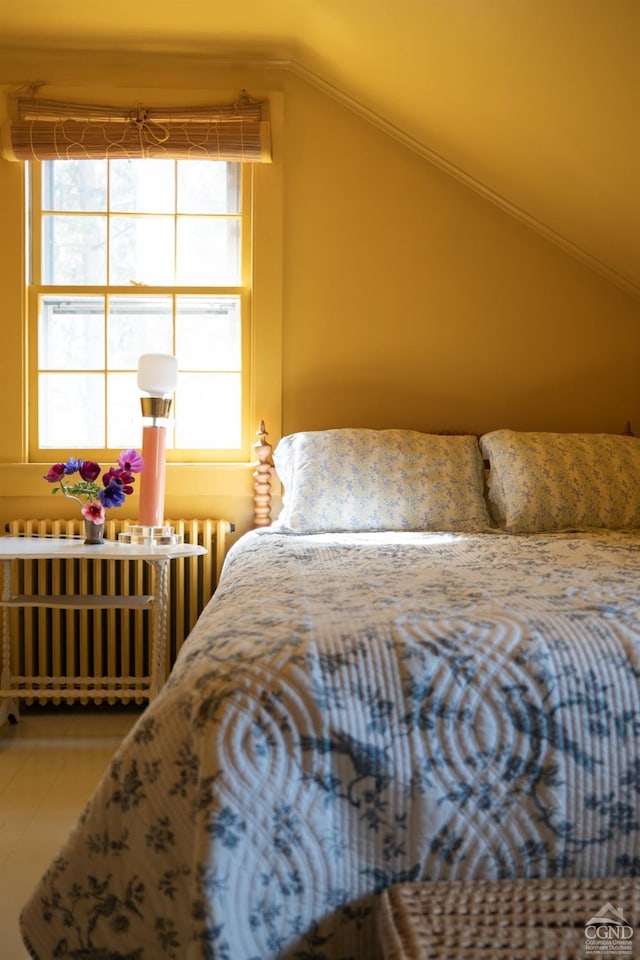 bedroom with radiator and lofted ceiling