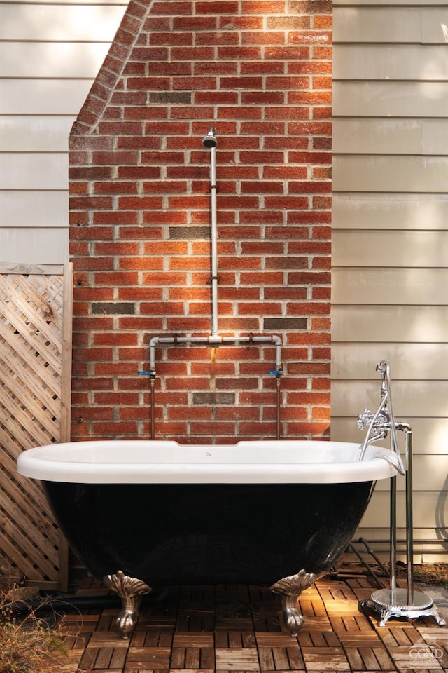 interior space featuring a freestanding bath and wooden walls