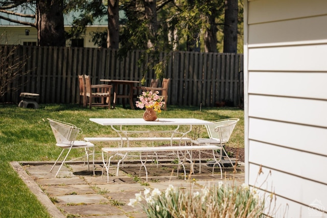 exterior space featuring outdoor dining area and fence