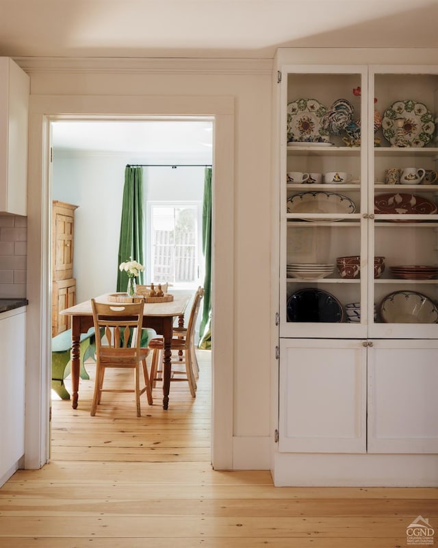doorway to outside featuring ornamental molding and light wood-style floors