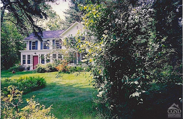 colonial house featuring a front lawn