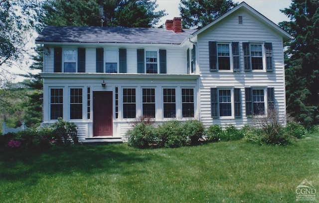 view of front of house featuring a chimney and a front lawn