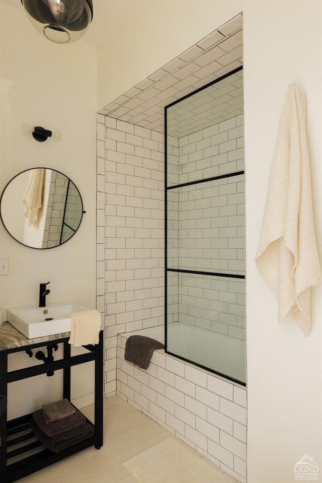 bathroom featuring combined bath / shower with glass door, tile patterned flooring, and sink